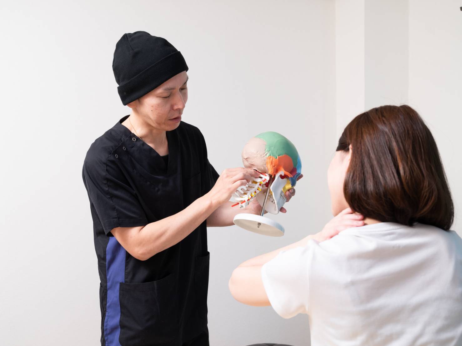 模型を使い、身体についてわかりやすく説明する施術者